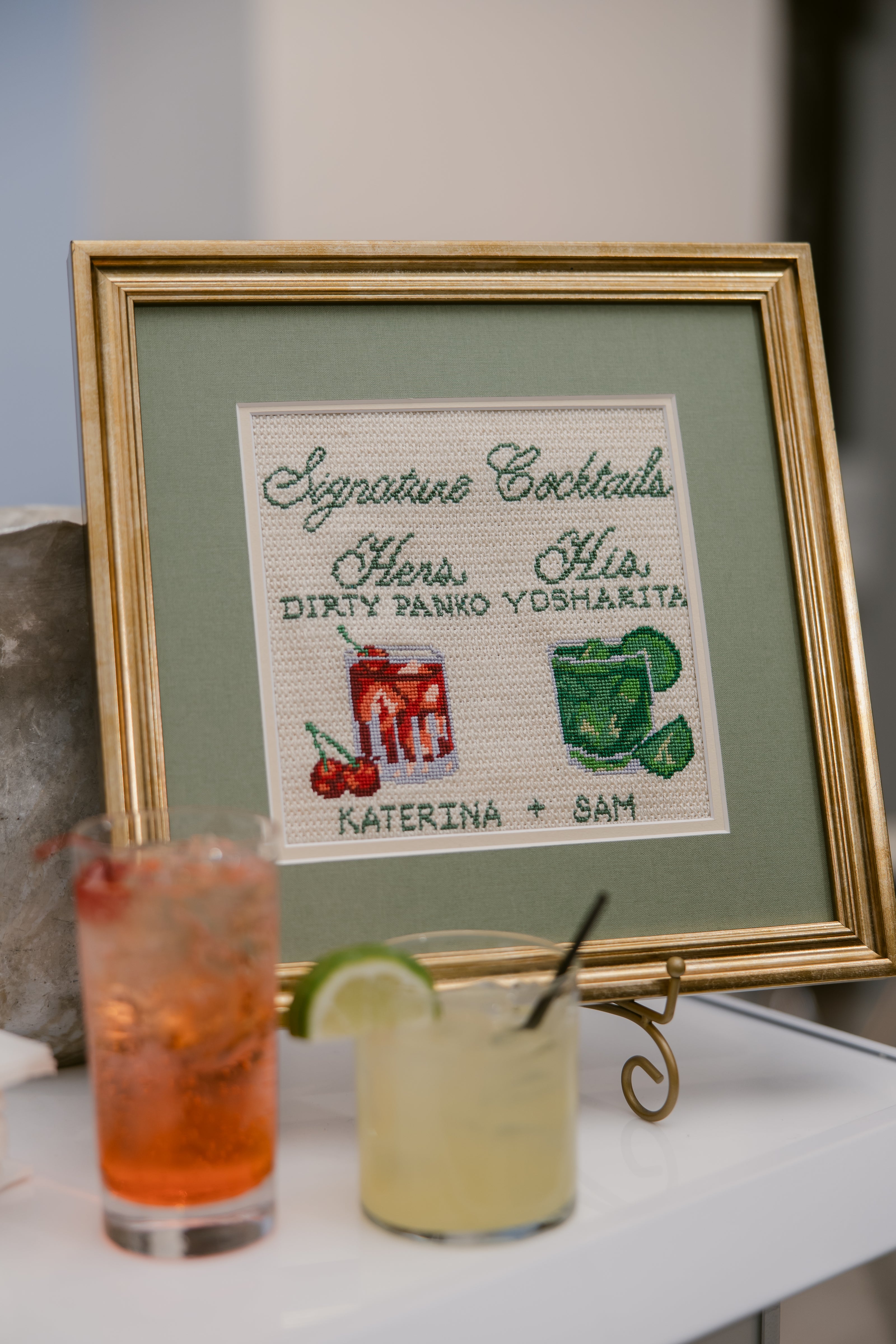 custom hand-painted needlepoint signature drinks sign displayed at a wedding